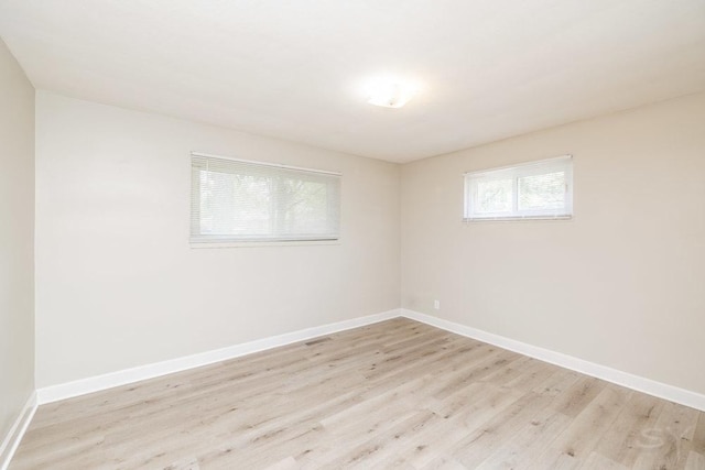 spare room featuring light wood finished floors and baseboards