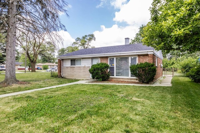 ranch-style home with a front yard, a chimney, and brick siding