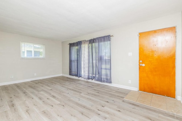 empty room featuring light wood-style flooring and baseboards