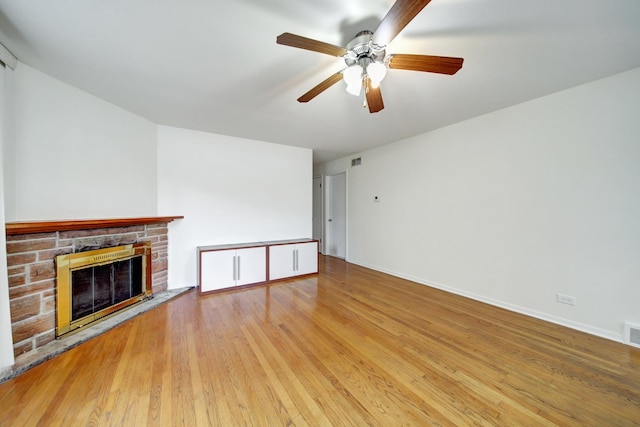 unfurnished living room featuring wood-type flooring, ceiling fan, and a fireplace