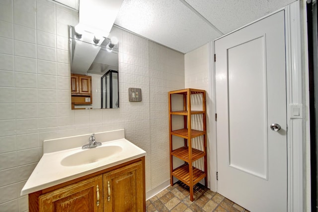 bathroom with vanity, tile walls, and a drop ceiling