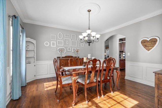 dining area featuring dark wood-type flooring, crown molding, and a chandelier