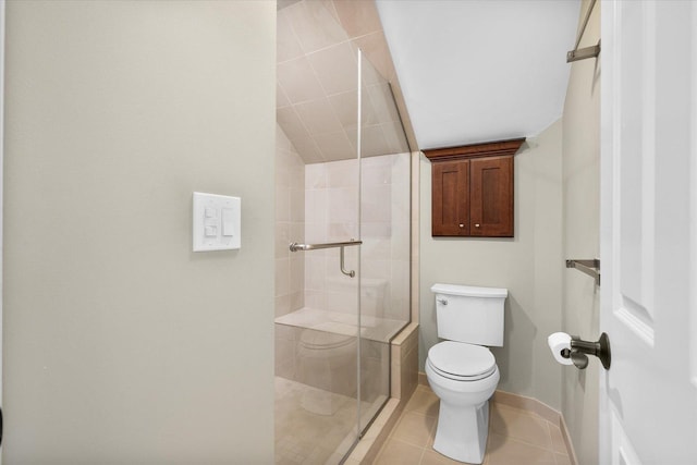 bathroom featuring tile patterned floors, toilet, and a shower with door