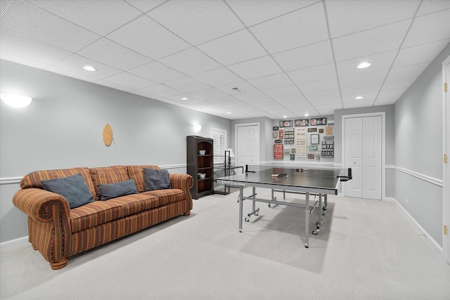 rec room with a paneled ceiling and light colored carpet