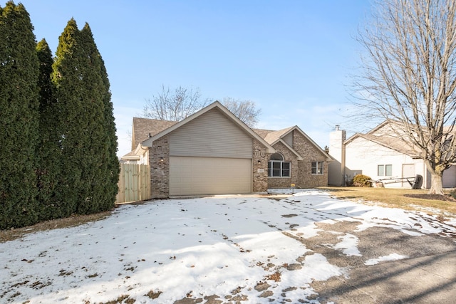 view of front of house featuring an attached garage and fence