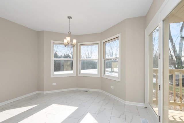 unfurnished dining area with marble finish floor, a notable chandelier, and baseboards