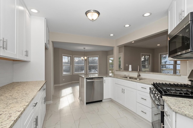 kitchen with white cabinetry, appliances with stainless steel finishes, and light stone counters