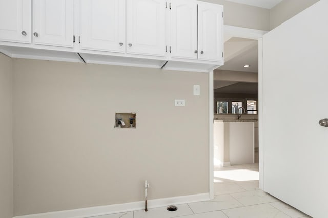 laundry room featuring washer hookup and cabinets