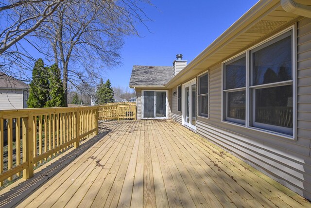 snow covered house featuring fence, a deck, and a yard