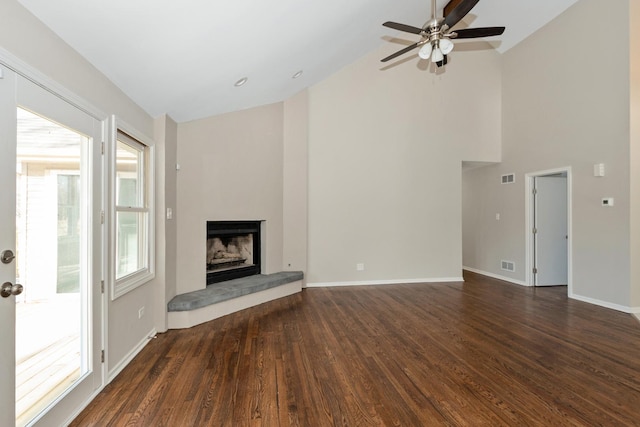 unfurnished living room featuring a fireplace, high vaulted ceiling, dark hardwood / wood-style floors, and ceiling fan