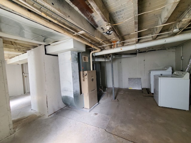 unfinished below grade area with washing machine and clothes dryer and heating unit