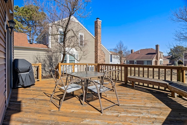 wooden terrace with outdoor dining area and area for grilling