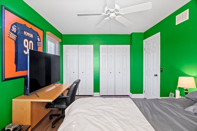 bedroom with multiple closets, visible vents, baseboards, and a ceiling fan