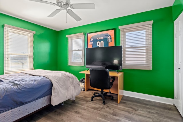 bedroom with a ceiling fan, baseboards, and wood finished floors