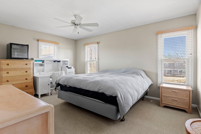 bedroom with light carpet, a ceiling fan, and baseboards