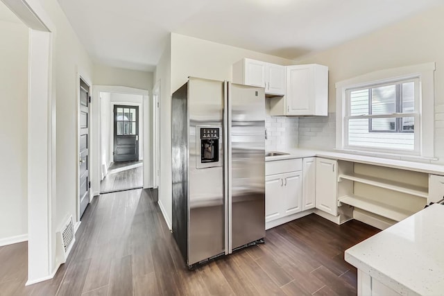 kitchen with white cabinetry, backsplash, stainless steel fridge, and dark hardwood / wood-style flooring