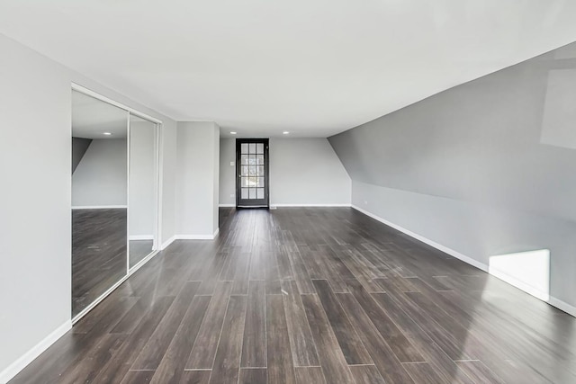 unfurnished room featuring dark hardwood / wood-style flooring and vaulted ceiling