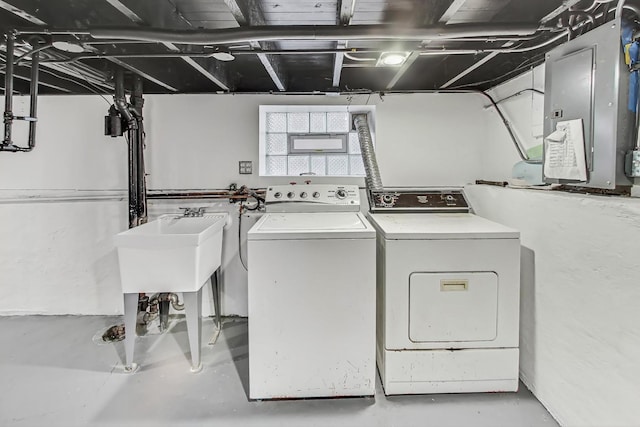 clothes washing area with electric panel and washing machine and dryer