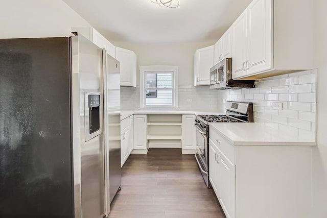 kitchen featuring stainless steel appliances, white cabinetry, tasteful backsplash, and dark hardwood / wood-style floors