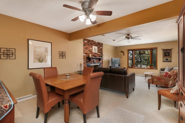 dining area featuring baseboards, a ceiling fan, a fireplace, and beamed ceiling