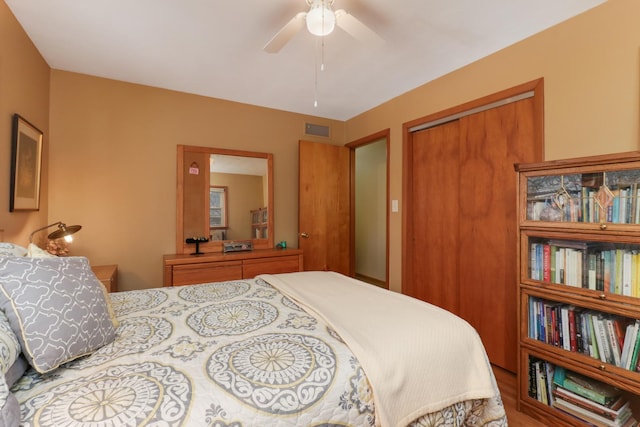 bedroom with ceiling fan, visible vents, and a closet