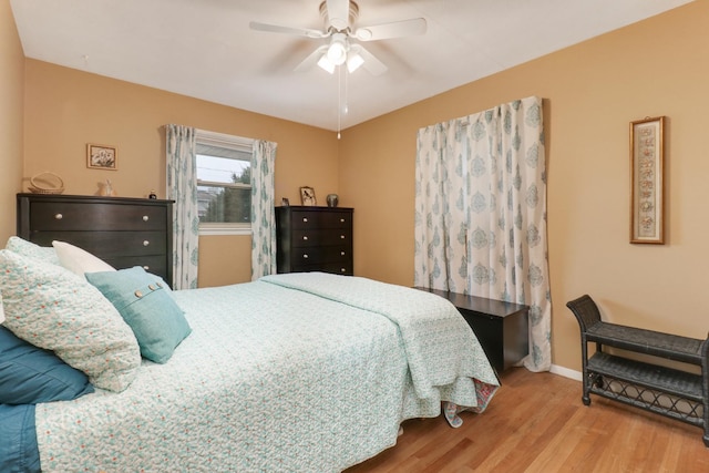 bedroom featuring a ceiling fan, baseboards, and light wood-type flooring