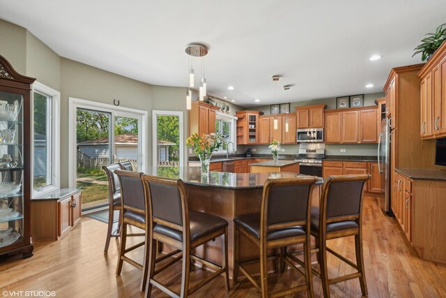 dining room with an inviting chandelier, a tray ceiling, and light wood-type flooring