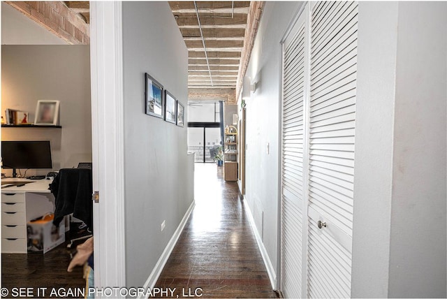 corridor featuring wood finished floors and baseboards