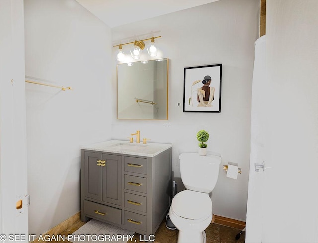 bathroom featuring baseboards, vanity, and toilet