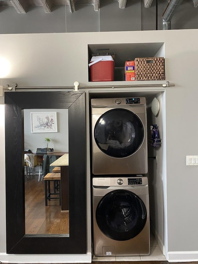 laundry room with stacked washer / drying machine, laundry area, and wood finished floors