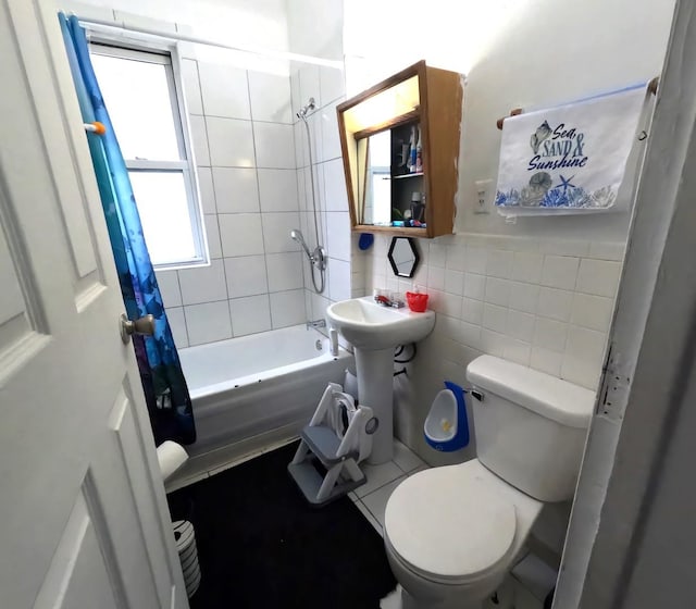 full bathroom featuring tile walls, sink, toilet, and shower / tub combo with curtain