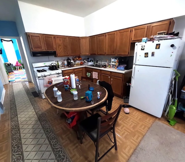 kitchen with white appliances, light parquet flooring, and a high ceiling