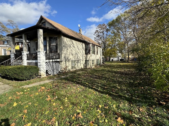 view of property exterior with a lawn and covered porch