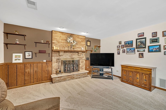 carpeted living room featuring a brick fireplace and wood walls