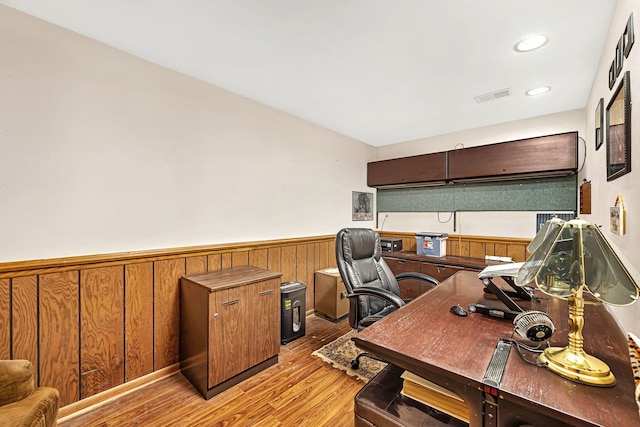 office area featuring wooden walls and light hardwood / wood-style floors