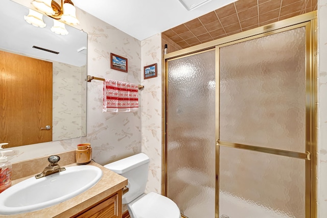 bathroom with walk in shower, vanity, and toilet