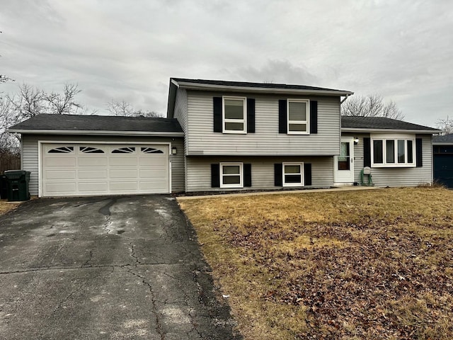 tri-level home featuring a garage and a front lawn