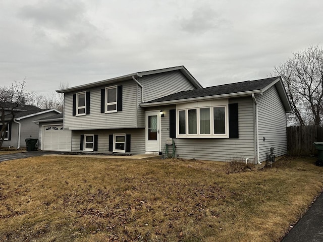 tri-level home featuring a garage and a front lawn