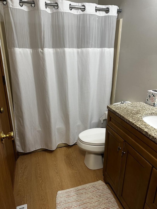 bathroom with vanity, hardwood / wood-style flooring, and toilet