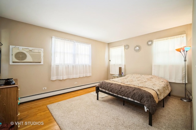 bedroom featuring wood finished floors and a baseboard radiator