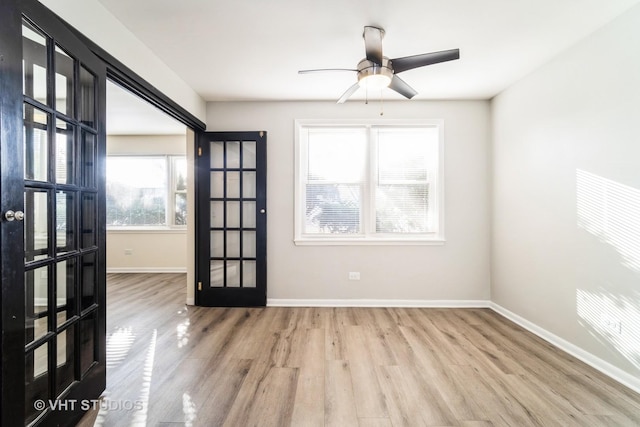 spare room featuring ceiling fan, french doors, baseboards, and wood finished floors