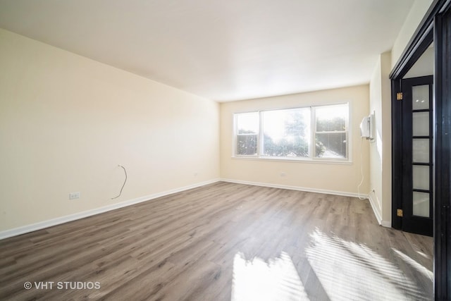 unfurnished room featuring wood finished floors and baseboards