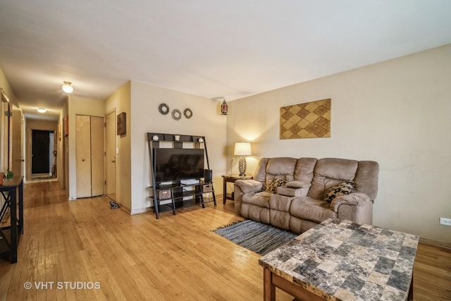 living area with baseboards and light wood-type flooring