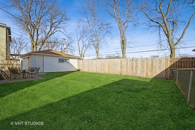 view of yard featuring an outbuilding, a patio, and a fenced backyard