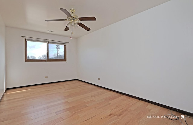 unfurnished room with a ceiling fan, visible vents, baseboards, and light wood-type flooring