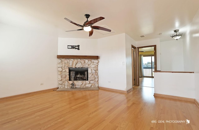 unfurnished living room featuring a fireplace, baseboards, and wood finished floors