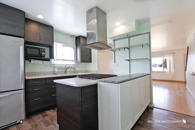 kitchen with a sink, dark wood-type flooring, island exhaust hood, and stainless steel appliances