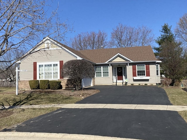 view of front facade featuring aphalt driveway and roof with shingles