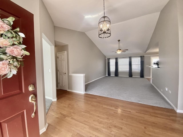 foyer with light wood-style flooring, baseboards, and vaulted ceiling