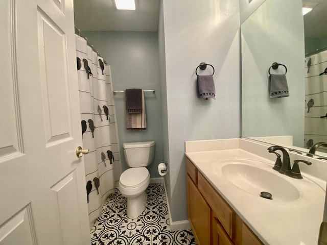 bathroom with tile patterned floors, baseboards, toilet, and vanity